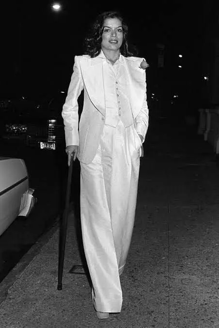 Bianca Jagger wearing a structured white Yves Saint Laurent suit
