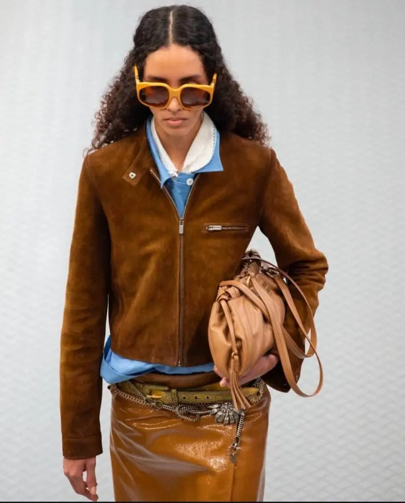 Model in brown suede jacket and glossy skirt from Miu Miu Spring 2025
