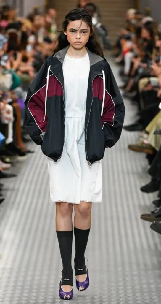 Model wearing sporty white dress and sneakers from Miu Miu Spring 2025