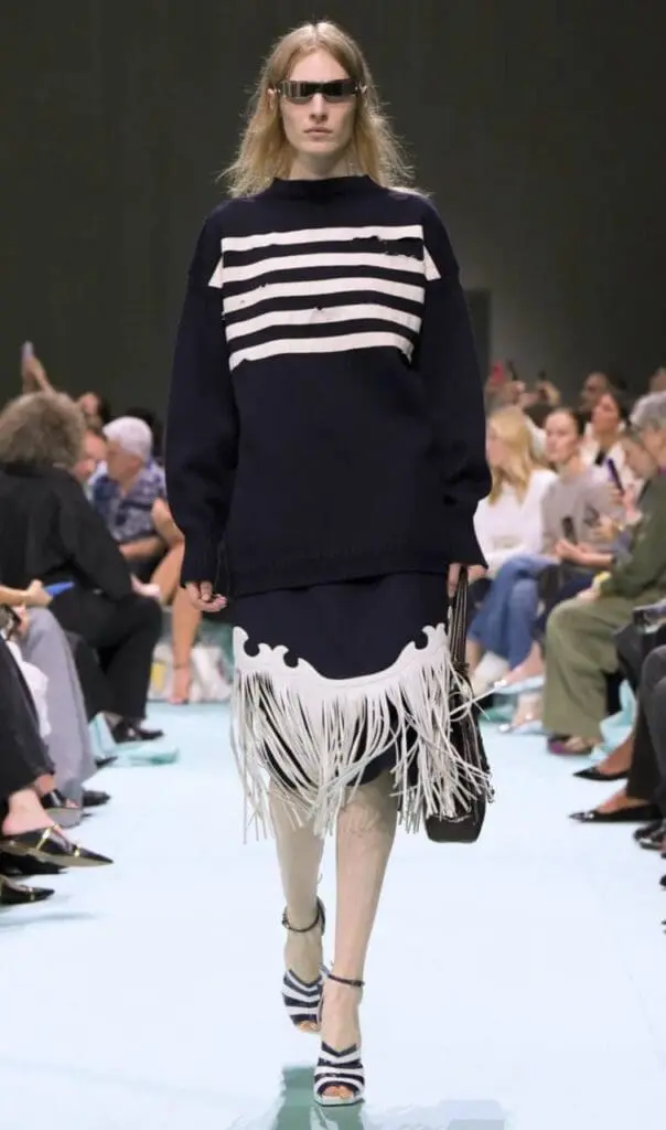 Model in navy striped sweater with fringe hem at Prada 2025