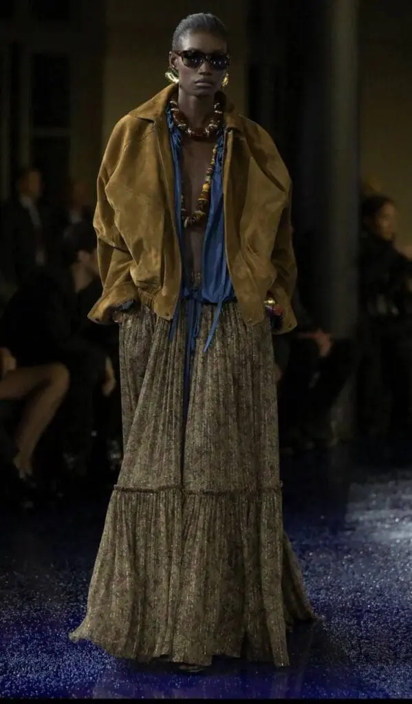 Model wears brown suede jacket with layered bohemian skirt