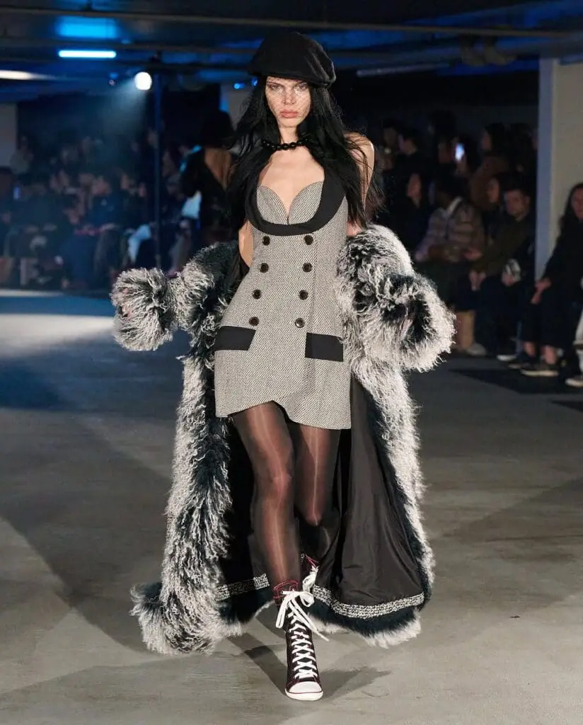 Model in cutout tweed mini dress with oversized faux fur coat at Sinead Gorey AW25
