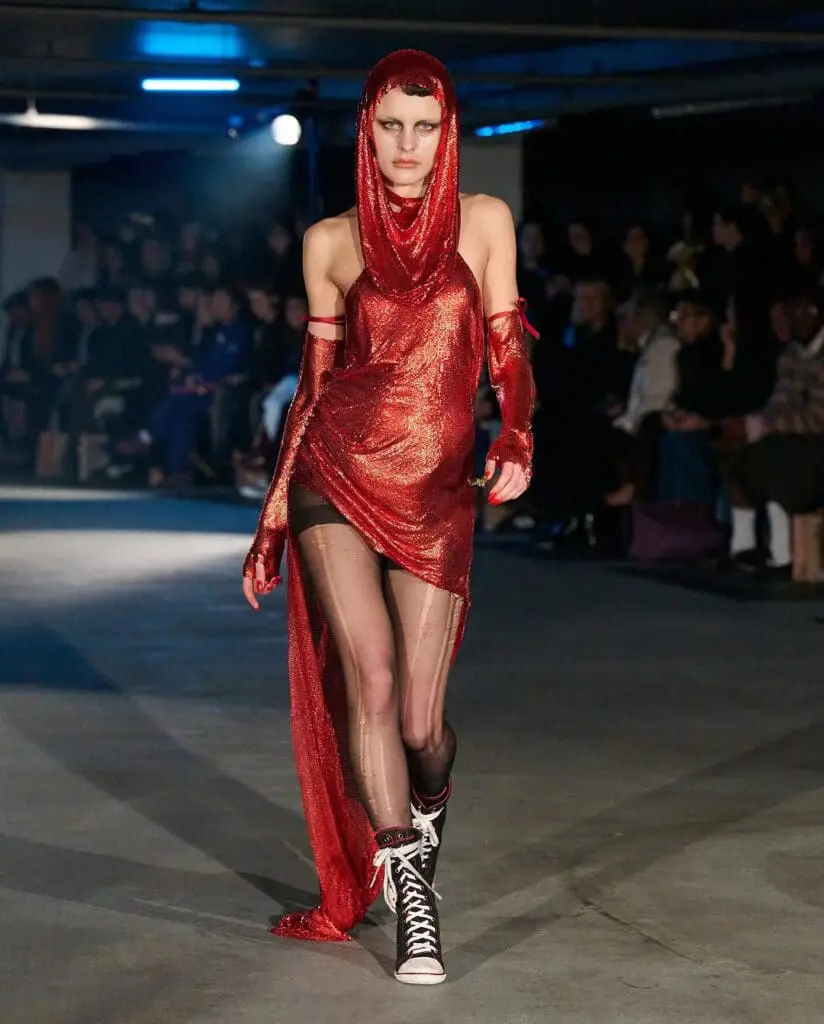 Model in red glitter hooded dress with dramatic slit at Sinead Gorey AW25 runway
