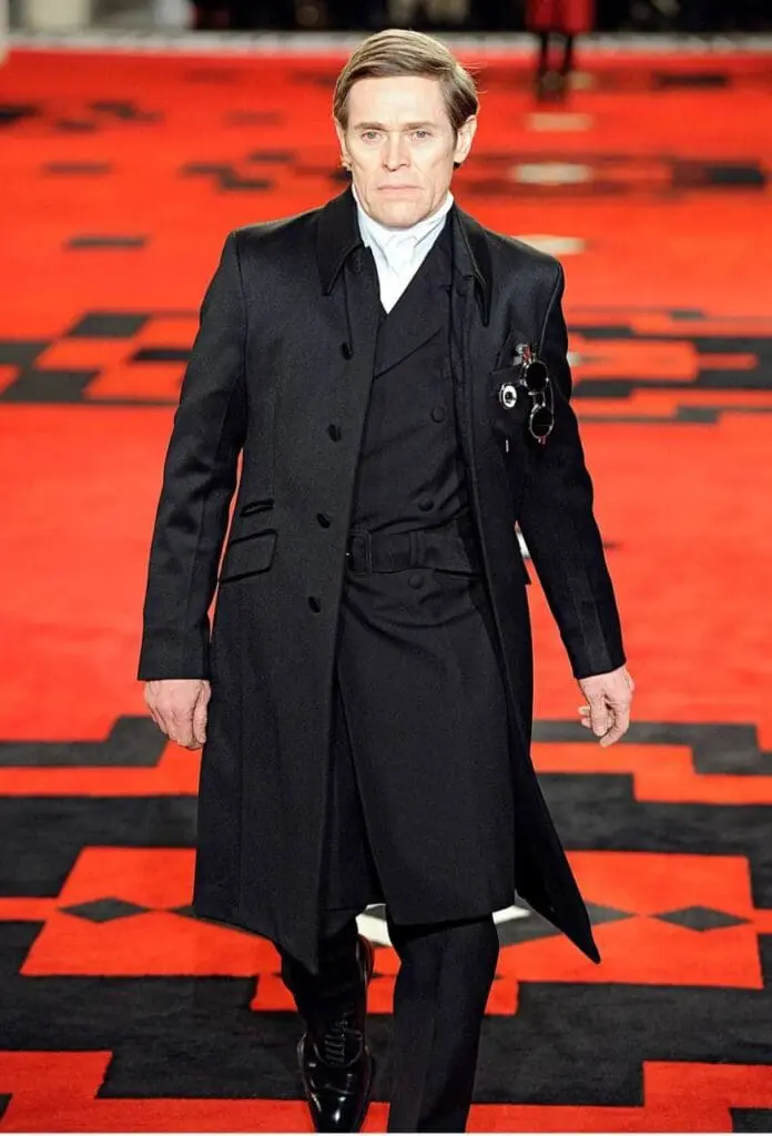 Willem Dafoe in a dramatic dark three-piece Prada look on red carpet