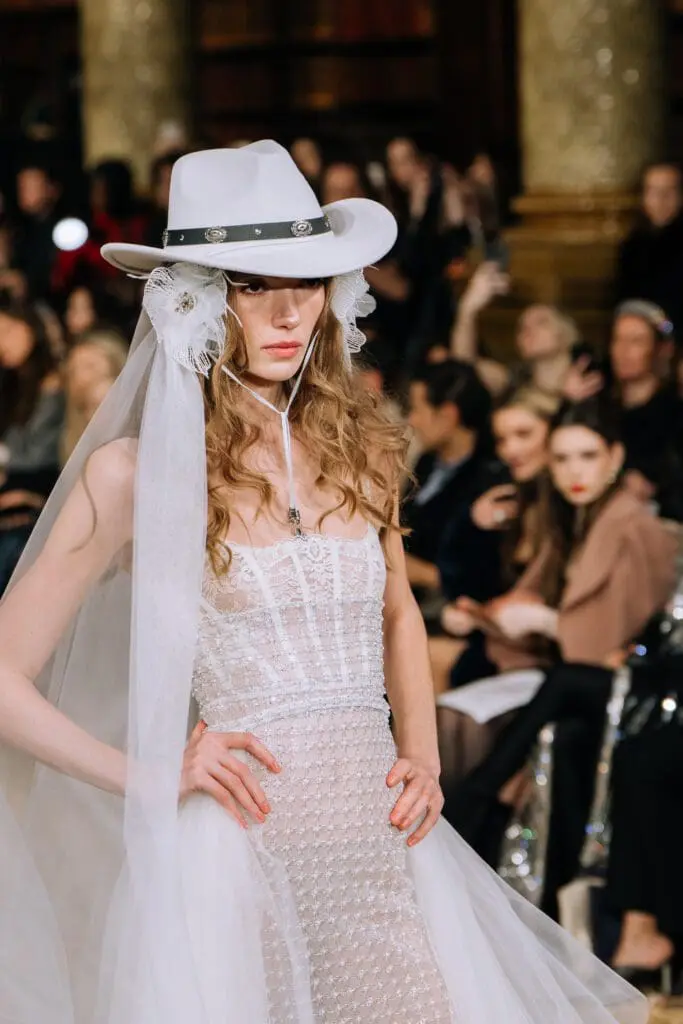 White lace bridal gown with white cowboy hat veil