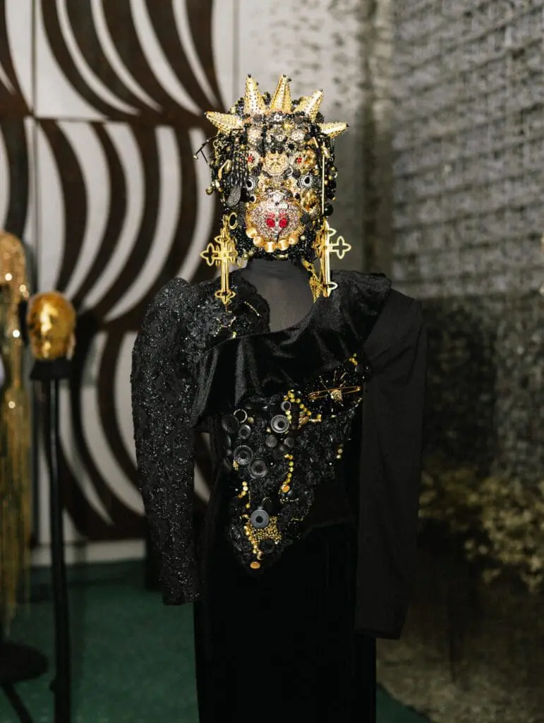 Black and gold ornamental mask with crosses and beads