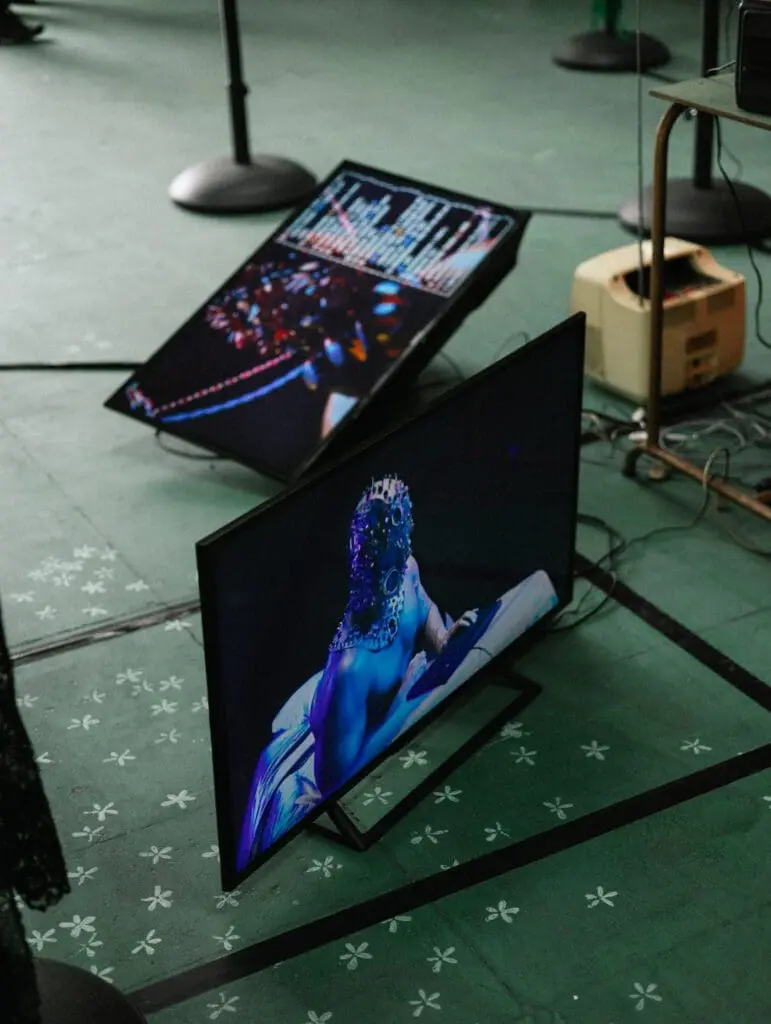 Screens showing digital projections of masks and performance