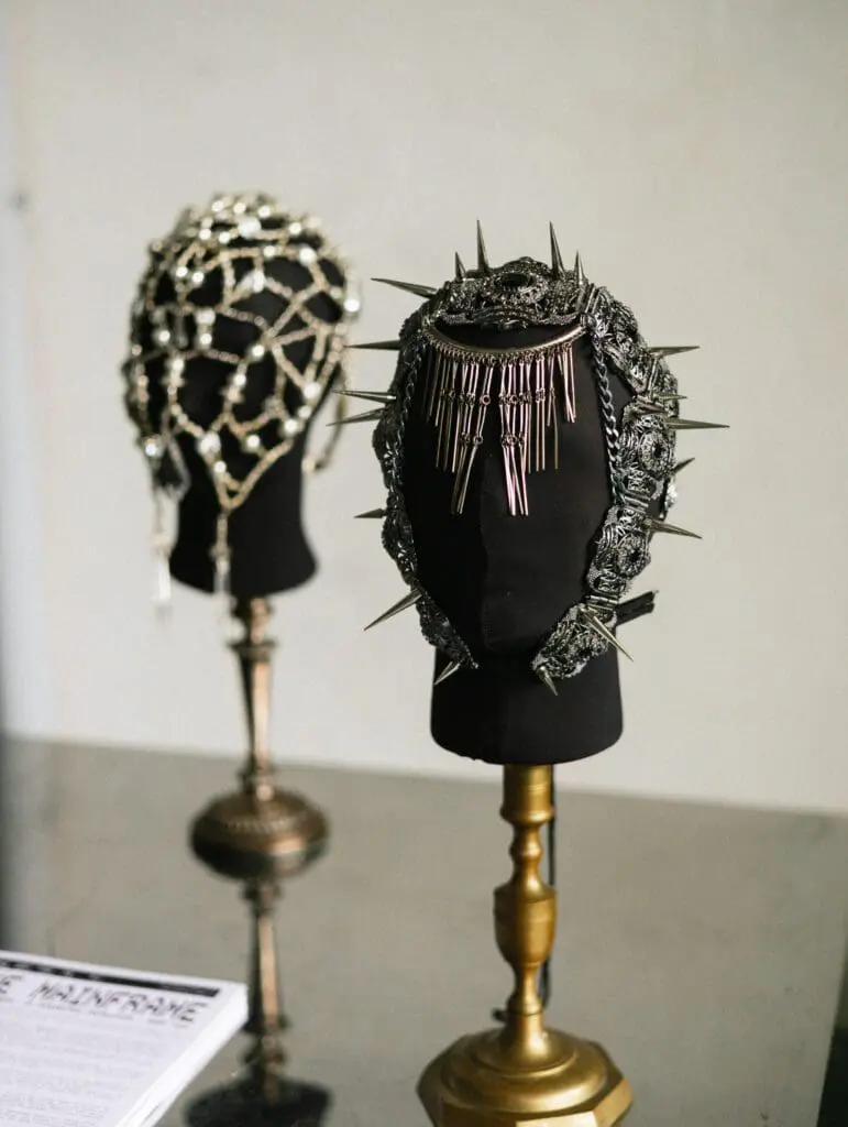 Metallic fashion masks with spikes and chains on stands