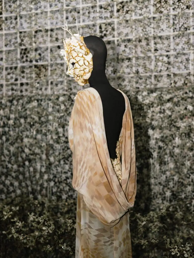 Golden ornamental mask with draped patterned costume