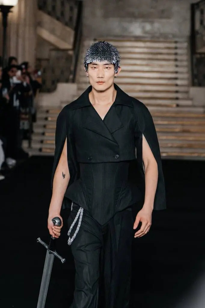 Male model in black suit with corset and sword