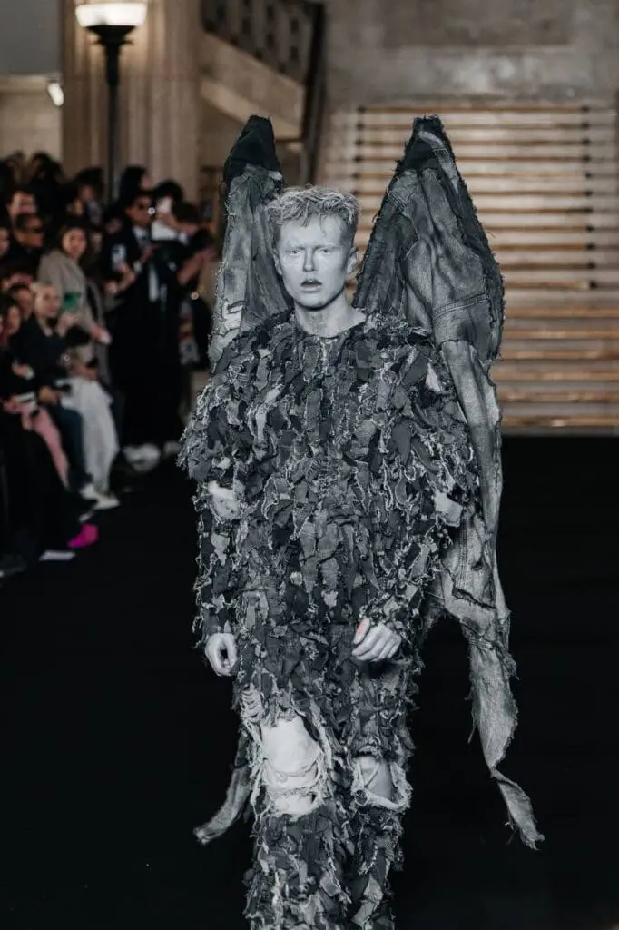 Model in grey textured wings and distressed fabric