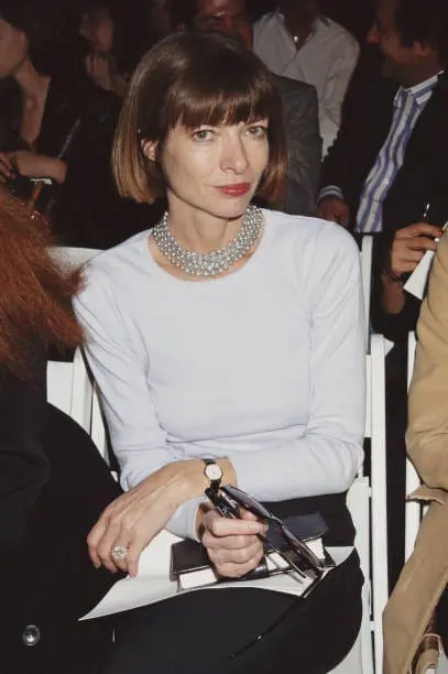 Anna Wintour in pearl choker seated at fashion week show