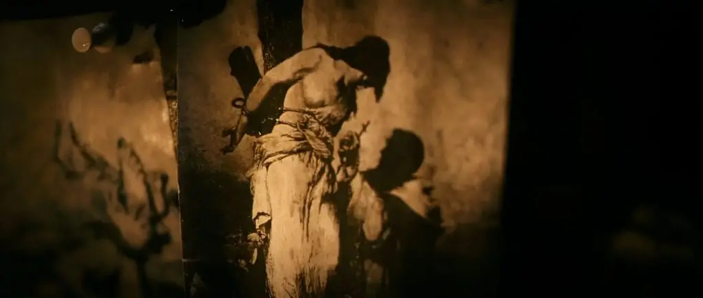 Crucifixion artwork with bound figure and shadow