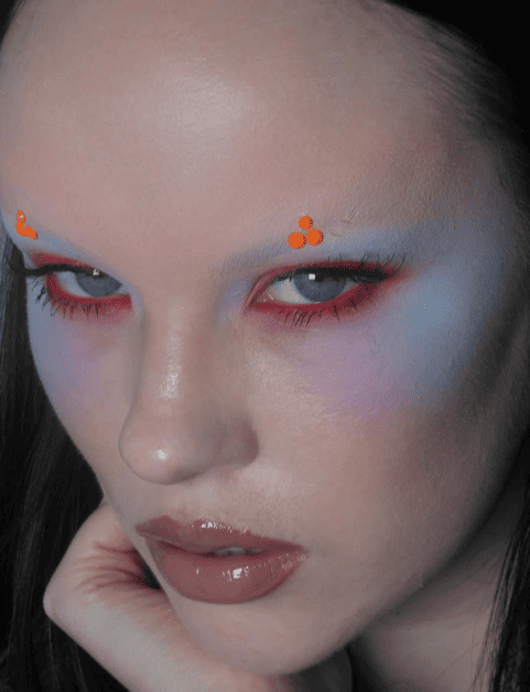 Model in warm metallic lip gloss and deep bronzer with bold lashes