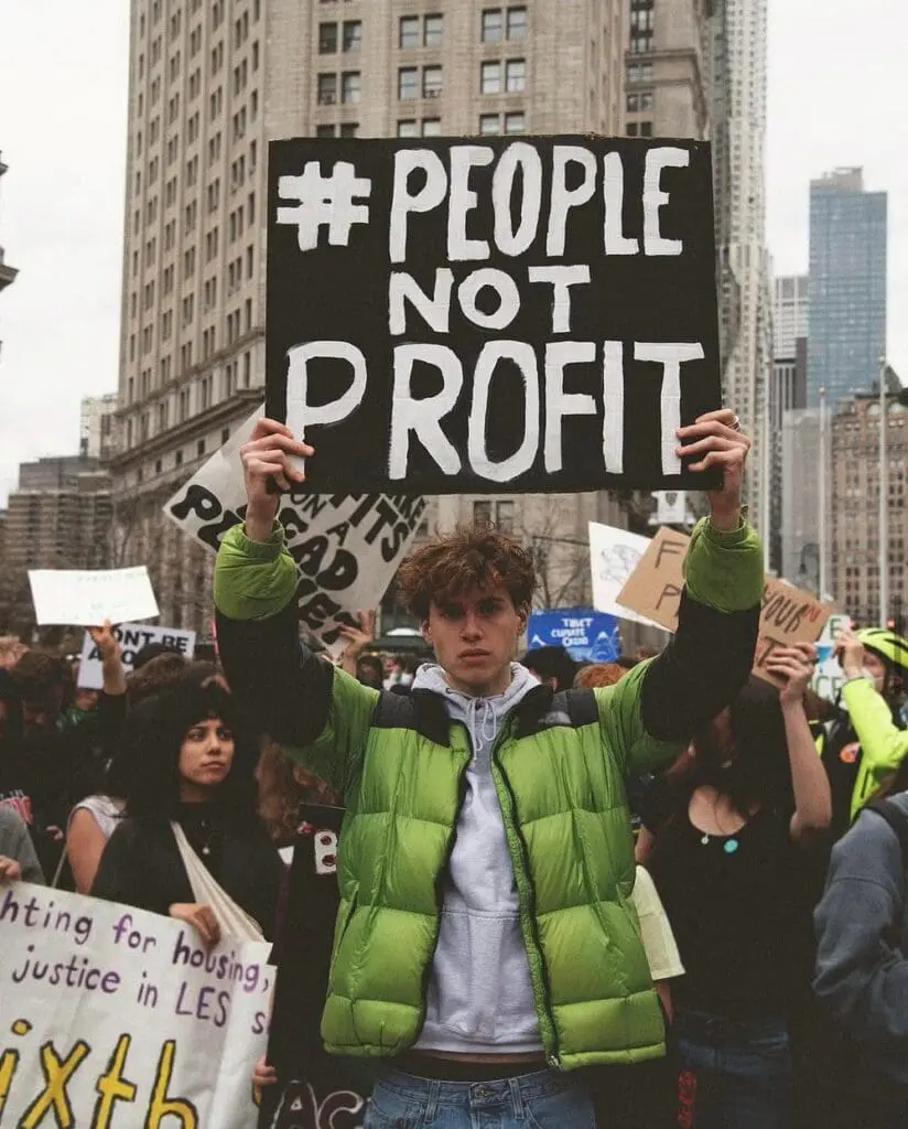 Protesters holding People Not Profit sign