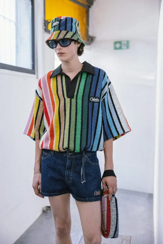 Model in rainbow striped polo and denim shorts SS26