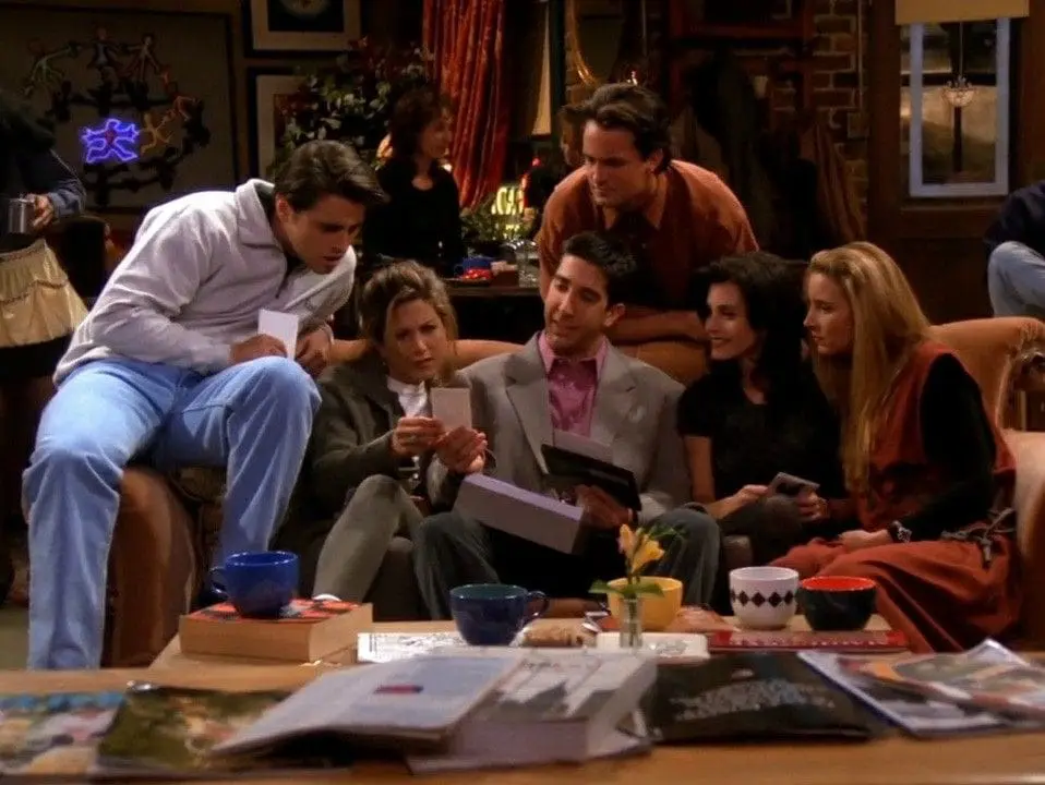 Friends female cast wearing wedding dresses on couch