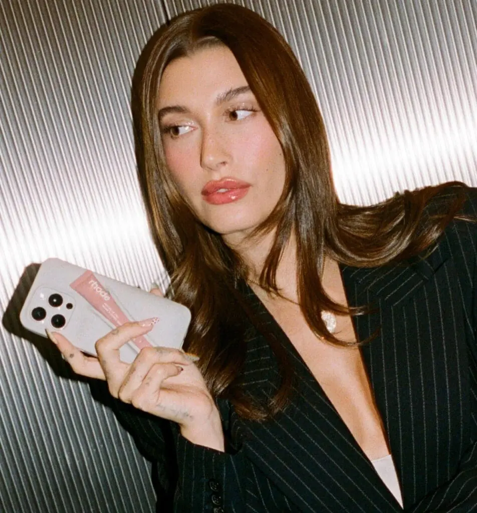 Hailey Bieber holding iPhone with Rhode lip gloss case