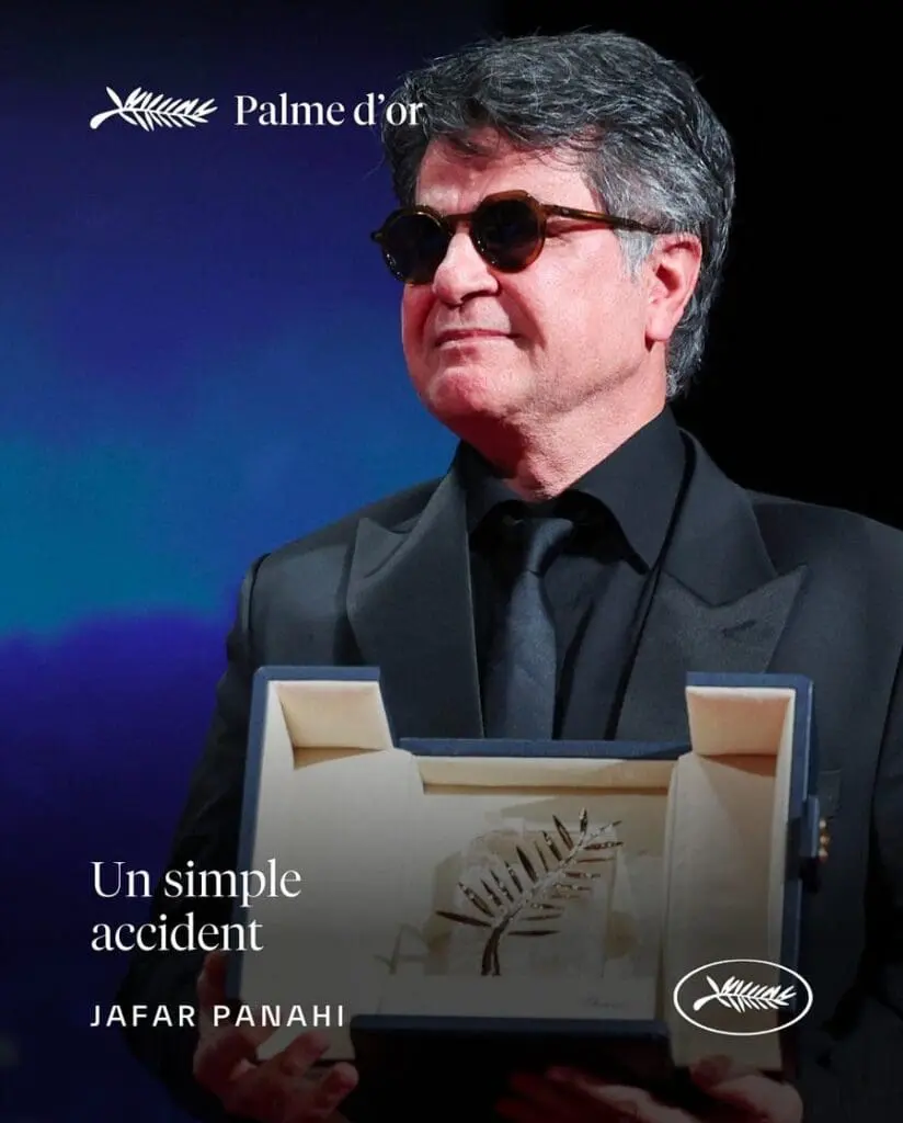 Jafar Panahi in sunglasses holding Palme d’Or trophy on stage