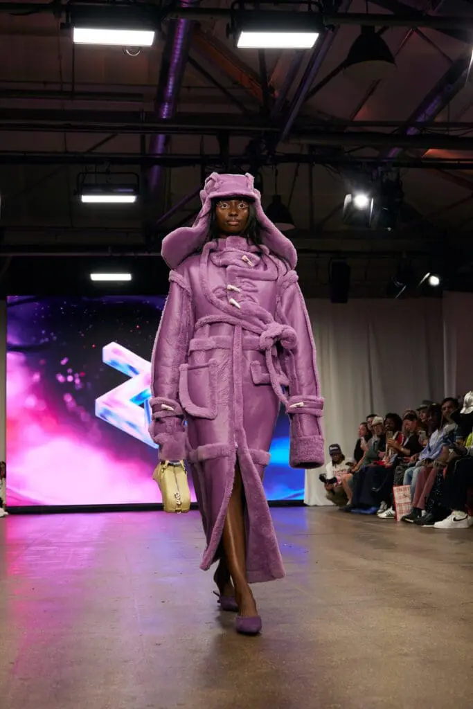 Model in purple shearling coat on London runway
