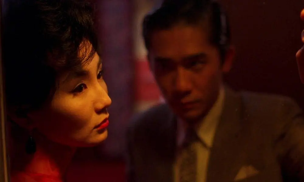 Su Li-zhen gazes past the mirror as Chow Mo-wan lingers behind her