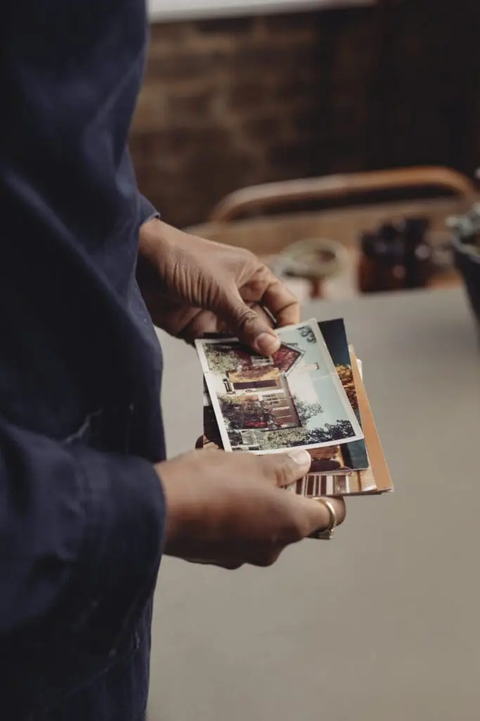 Close-up of Maya Njie’s hands holding nostalgic photographs