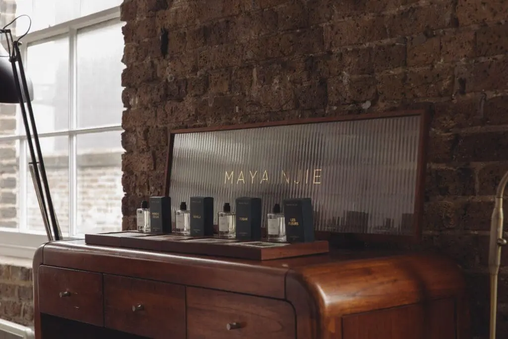 Maya Njie’s full fragrance line arranged on wooden furniture