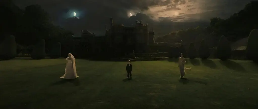 Family standing on lawn with two moons above