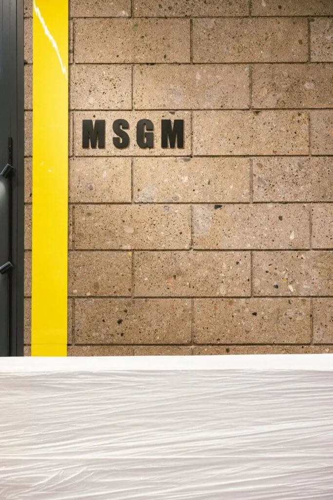 MSGM store installation with brand logo on brick wall