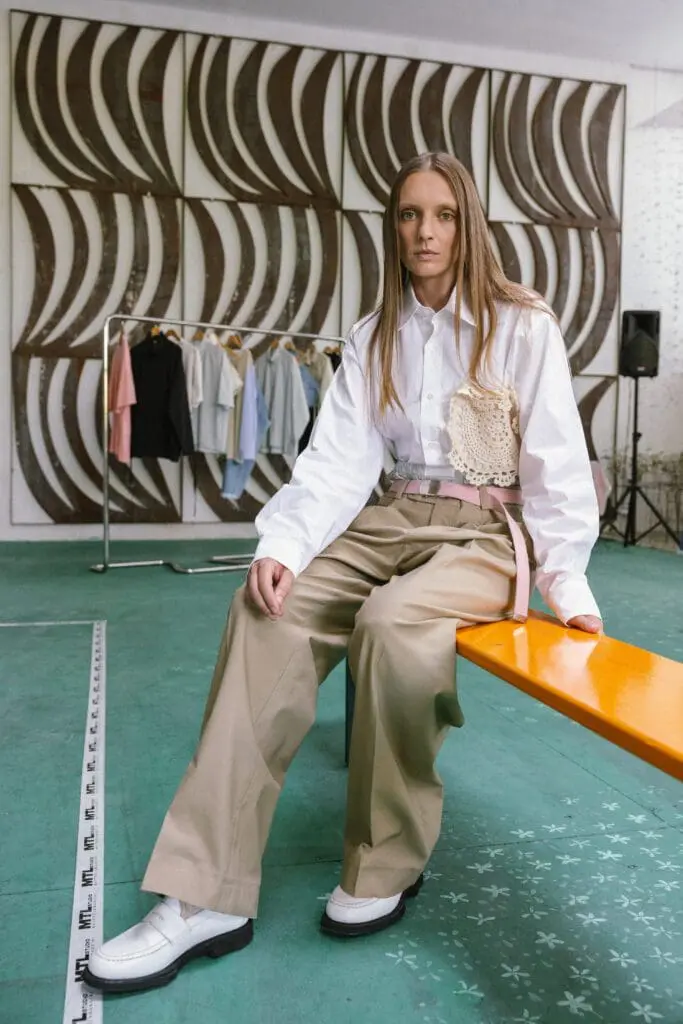 Female model in white shirt and beige wide trousers