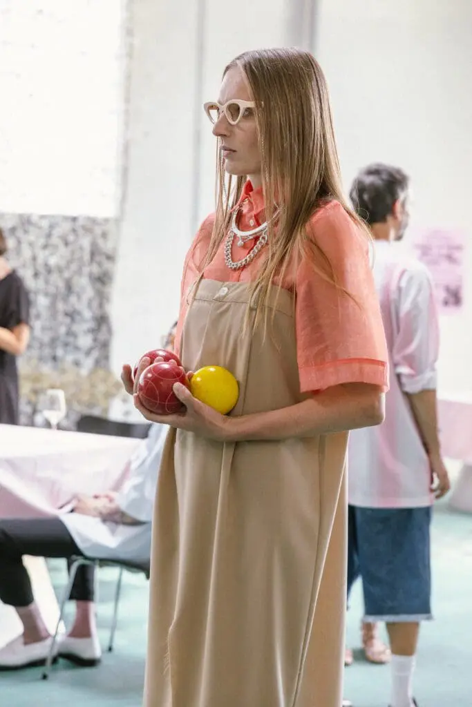 Female model holding red and yellow bocce balls