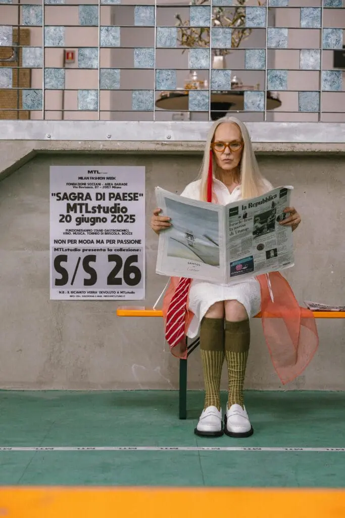 Female model reading newspaper near event poster