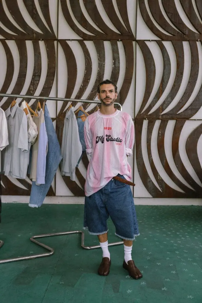 Male model in pink striped shirt and denim shorts