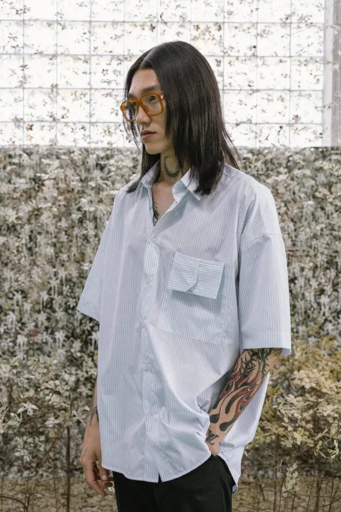 Male model with tattoos wearing striped shirt