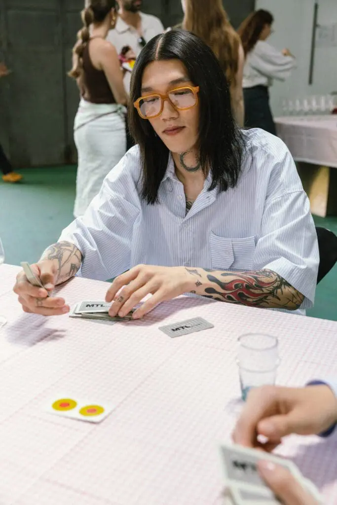 Male model in striped shirt playing cards indoors