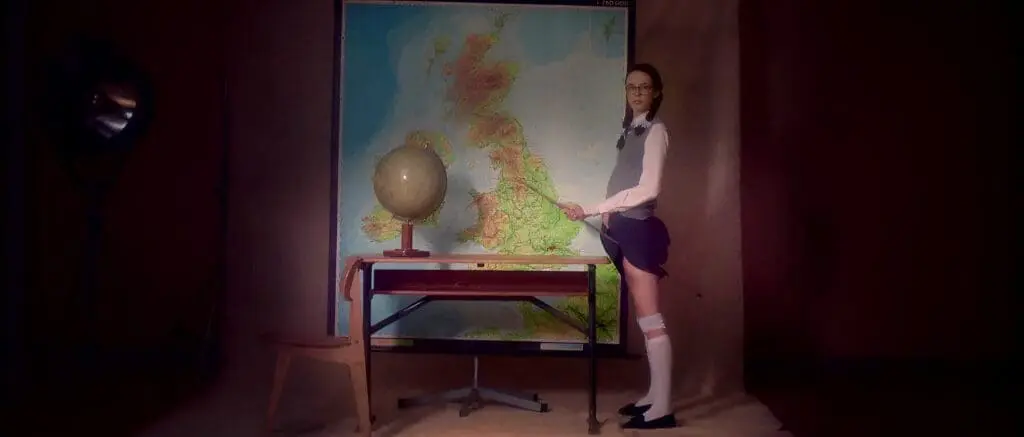 Woman in classroom with globe and large map