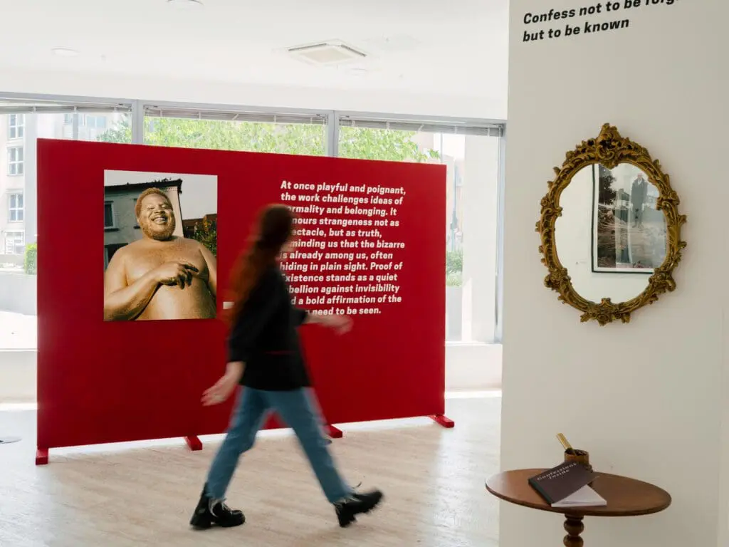 Gallery display with red wall and mirrored corner
