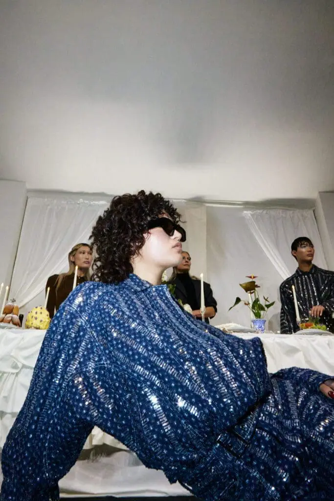 Model in shimmering blue sequined top at fashion presentation