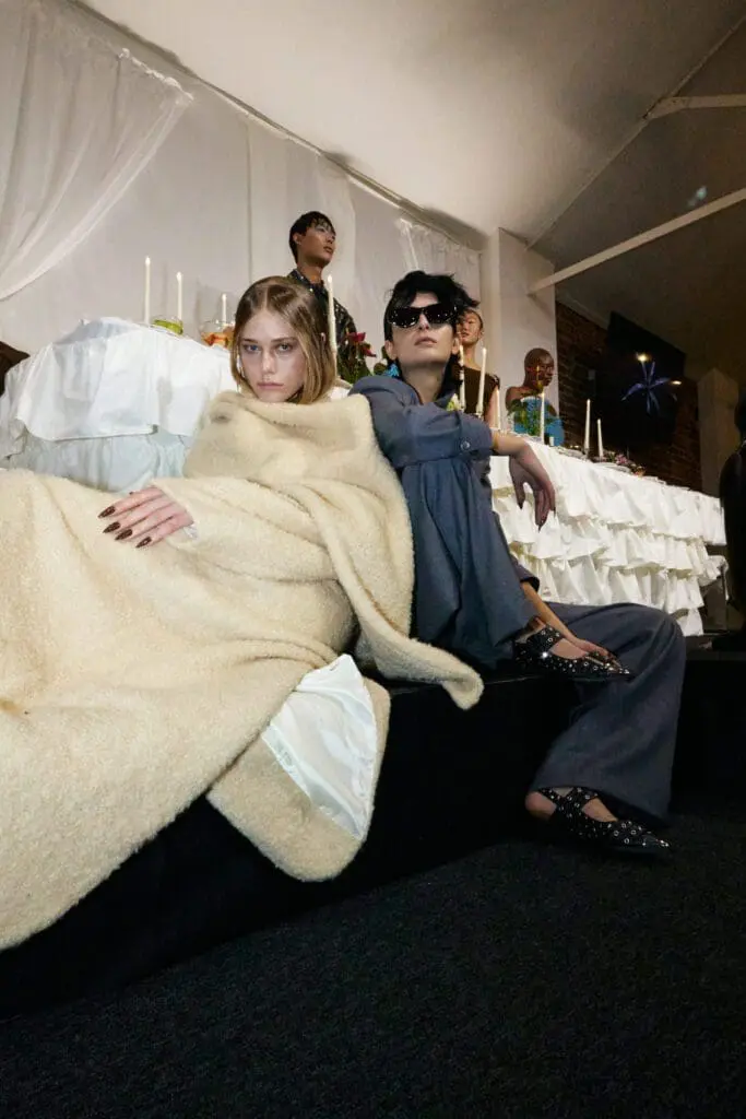 Models in cream jacket and grey suit at fashion show