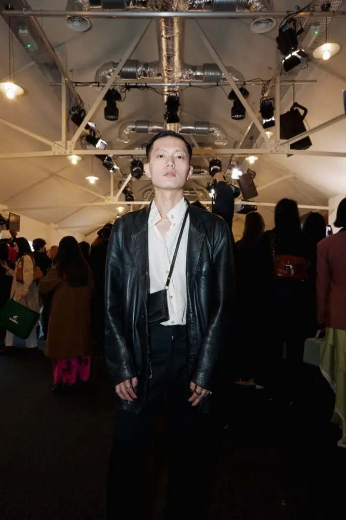 Model in black leather jacket and white shirt at fashion show
