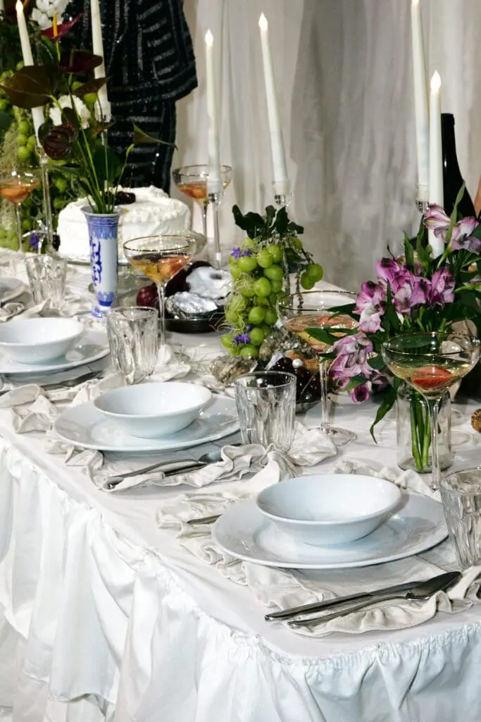 Opulent dining table set with candles, flowers, and fruits