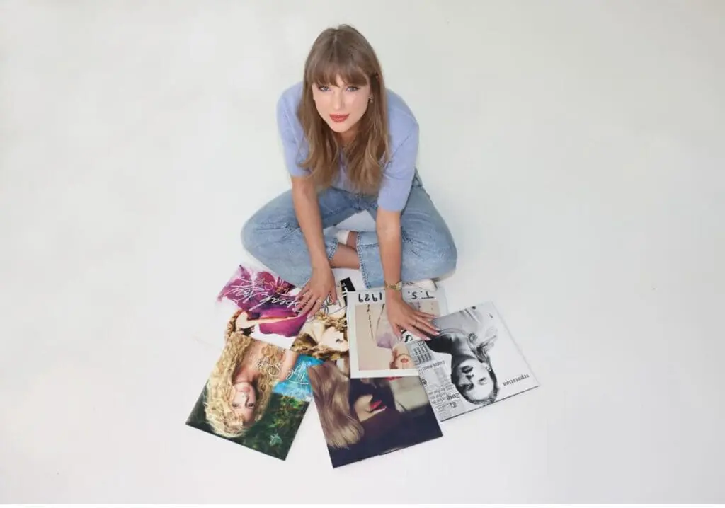 Taylor Swift sitting on the floor surrounded by her re-recorded albums