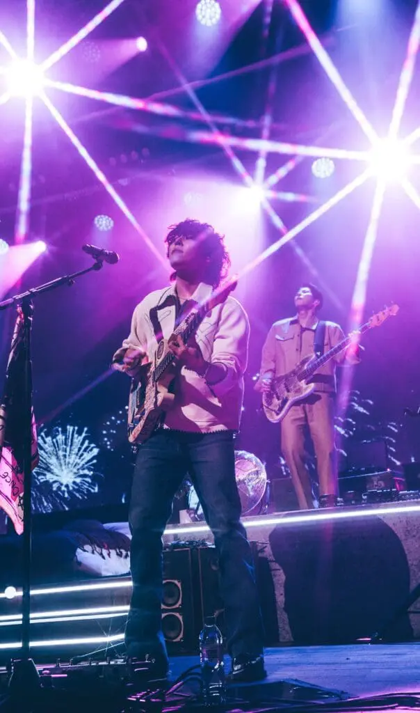 Dojoon and Jaehyeong performing on a purple-lit stage