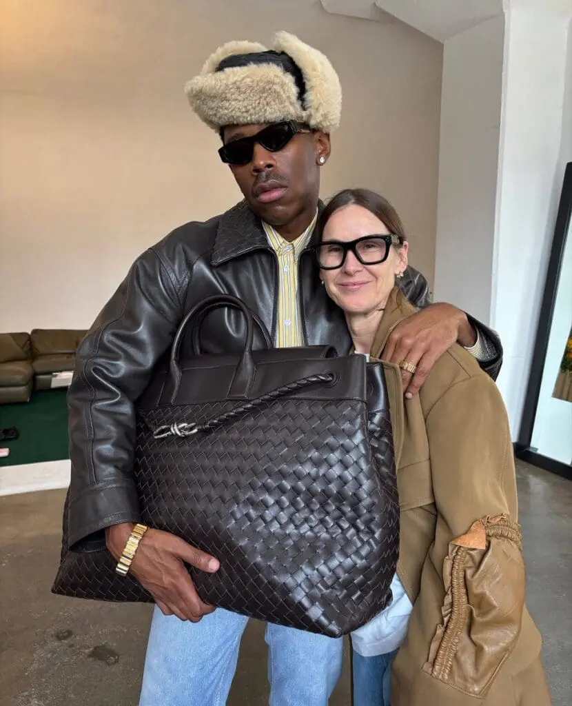 Tyler, The Creator hugs Louise Trotter holding Bottega’s signature woven leather bag