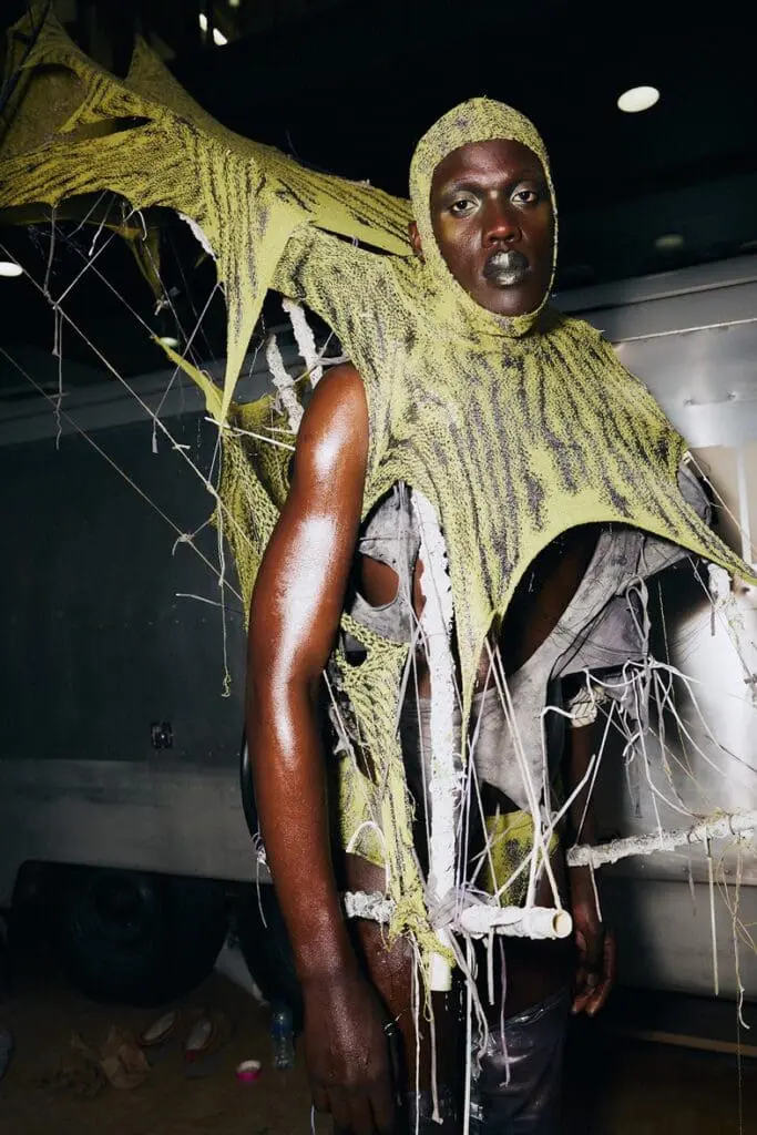 Model in shredded knit garment with arcing wings from Yodea’s Seven Sisters CSM collection