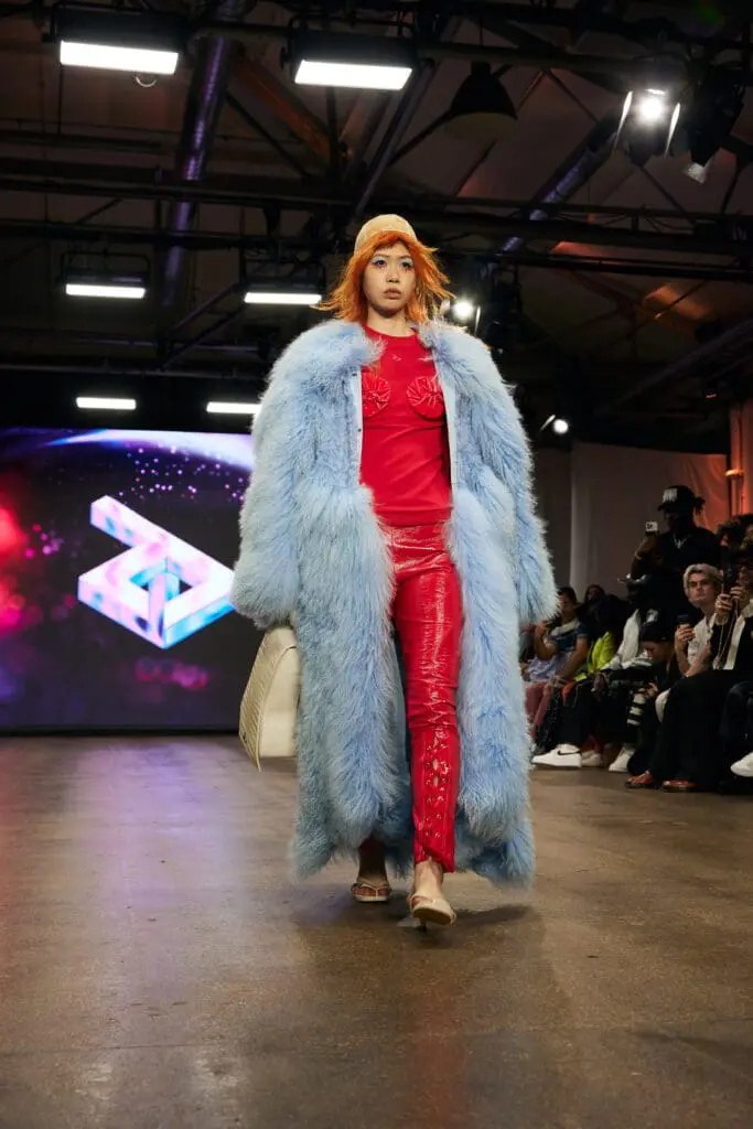 Powder-blue faux-fur coat over red top and glossy red trousers on the ZIDI runway.