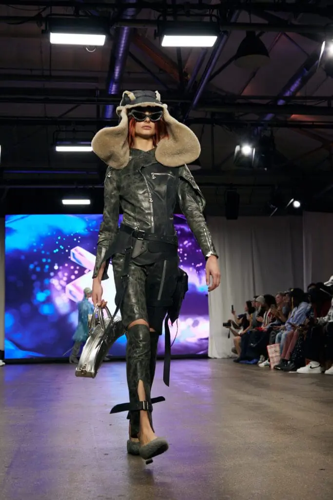 Distressed black leather set with an oversized shearling trapper hat and silver bag.