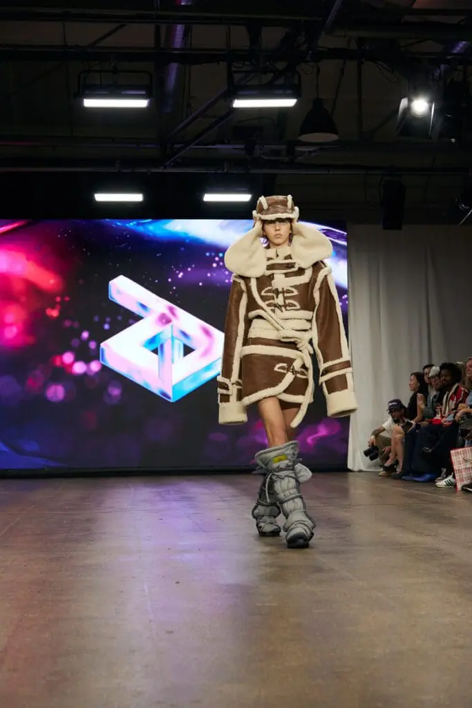 Brown and cream shearling aviator coat paired with padded moon boots on the ZIDI runway.