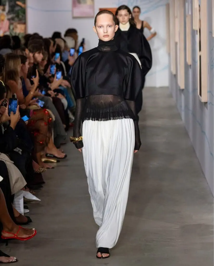 Ashlyn runway model in black top and white trousers NYFW