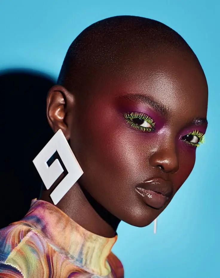 Black model with vibrant makeup and bold earrings